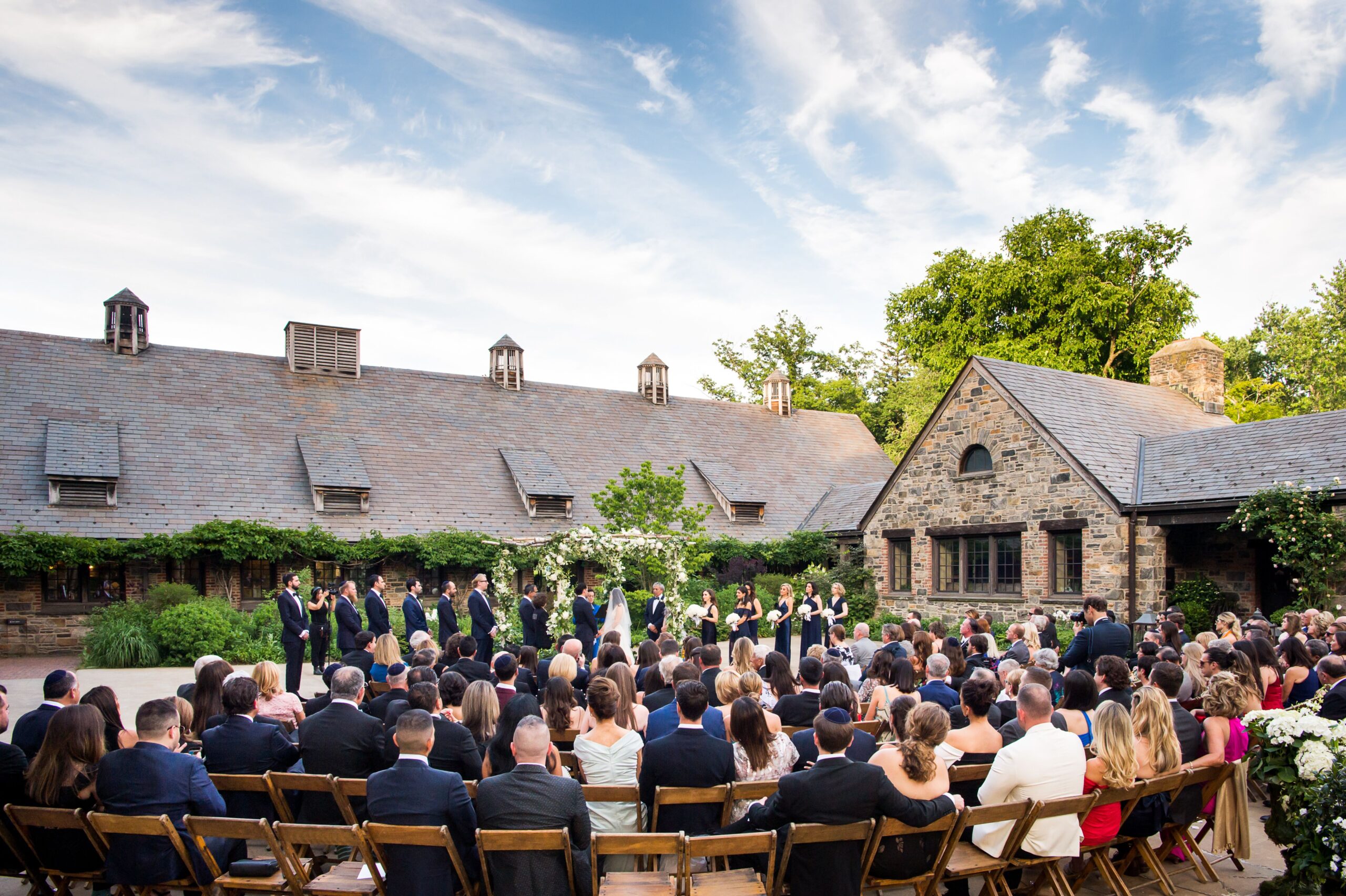 Outdoor blue hill at stone barn wedding ceremony